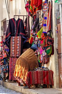 A shop in a narrow street offers colourful, handmade textiles and clothing with traditional