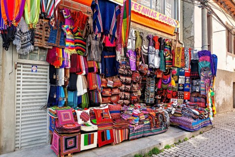 A market stall with colourful, handmade textiles and artistically designed fabrics at a lively