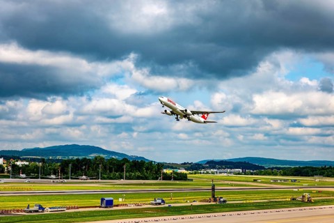 Swiss Airlines Passenger Airplane Take Off From the Runway and Flying Against Blue Sky and Clouds