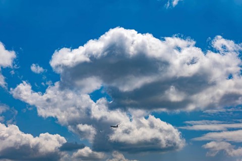 Passenger Airplane Flying Against Blue Sky and Clouds in a Sunny Summer Day From the Airport in