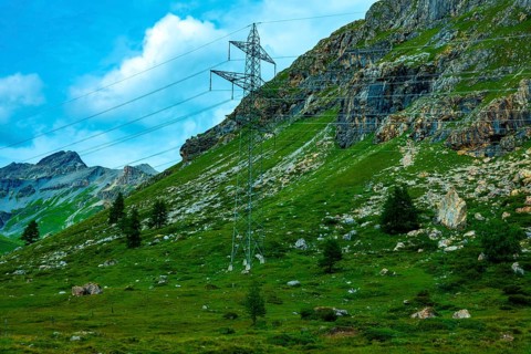 Electricity Pylon with Mountain View in the Swiss Alps in a Sunny Summer Day in Bernina,