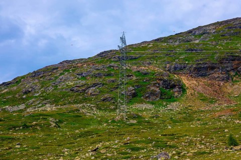 Electricity Pylon with Mountain View in the Swiss Alps in a Sunny Summer Day in Bernina,