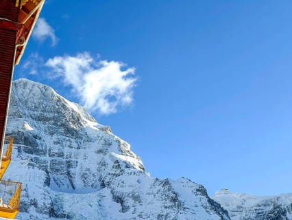 Hotel and Snowcapped Mountain Peak Mönch at 4107 Meter High in the Swiss Alps in a Sunny Winter Day