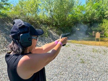 Woman Shooting in Motion on an Outdoor IPSC Shooting Range in a Sunny Summer Day in Switzerland
