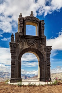 An imposing stone gate with fine details under a dramatic cloudy sky, The gate at the Killi Killi