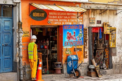 A small shop with an orange façade and various tools in an urban street scene, A small DIY store in