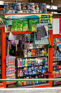 Variety of household products in a well-stocked, colourful supermarket, small shops and restaurants