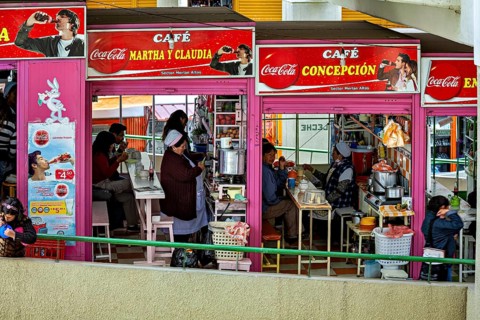 Friendly café with people eating, eye-catching Coca-Cola advert, Small shops and restaurants in the