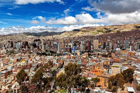 Cityscape with skyscrapers and cloudy sky in a mountain environment, The houses and skyscrapers of