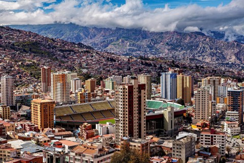 Panorama of La Paz with a view of skyscrapers and a stadium against a mountain backdrop, The houses