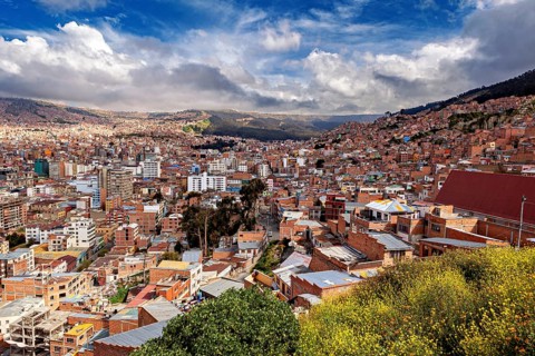 Hilly cityscape of La Paz with red roofs and cloudy skies, The houses and skyscrapers of the city