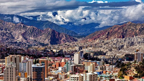 Panorama of a city surrounded by mountains and under a cloud cover, The houses and skyscrapers of