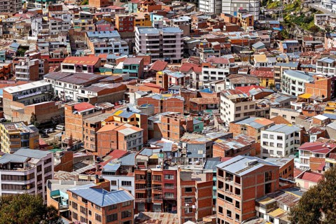 Dense cluster of houses with colourful roofs, The houses and skyscrapers of downtown La Paz in