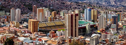 Urban scenery with stadium and skyscrapers in front of mountains, The houses and skyscrapers of the