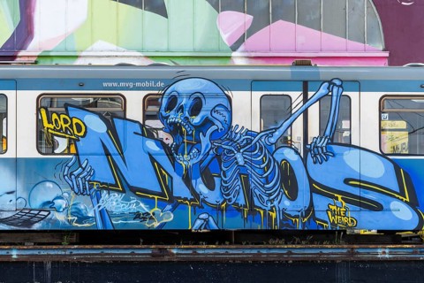 Blue skeleton graffiti art on a train with urban background, at the harbour of Linz Upper Austria