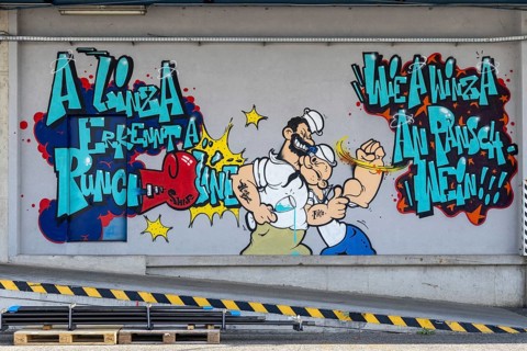 Colourful comic-style graffiti with fighting characters and lettering, at the port of Linz Upper
