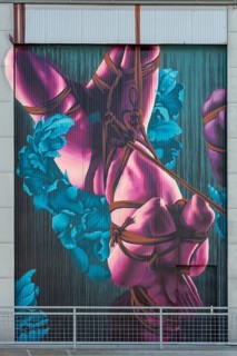 Colourful depiction of a body decoratively wrapped with flowers and ribbons, at the port of Linz,