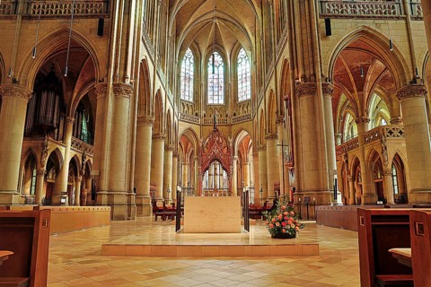 Magnificent interior of a Gothic church with high vaults and colourful stained glass windows, Maria