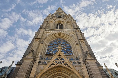 Detailed Gothic church façade rises dramatically into the cloudy sky, Maria Empfängnis Dom Linz