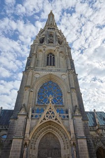 Gothic church façade with detailed stained glass windows and cloudy sky, Maria Empfängnis Dom Linz