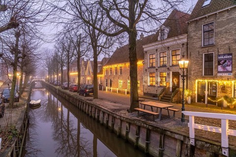 Typical canal in the foggy evening twilight, Harlingen, Friesland, Netherlands