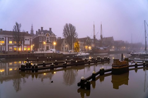 Typical canal in the foggy evening twilight, Harlingen, Friesland, Netherlands