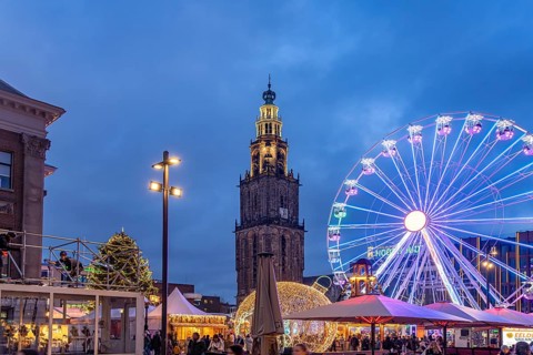 Ferris wheel on the Grote Markt at Christmas time and the Martinitoren or Martini tower of the