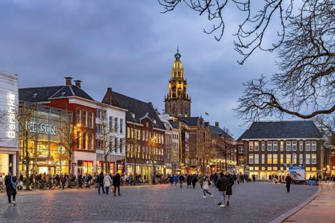 Shops at the fish market Vismarkt and the church tower Martinitoren or Martinitower of the