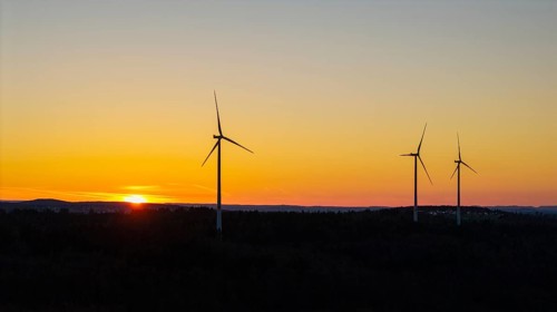 Wind turbines at dusk with an orange sky in the background, near Schorndorf im Remstal,