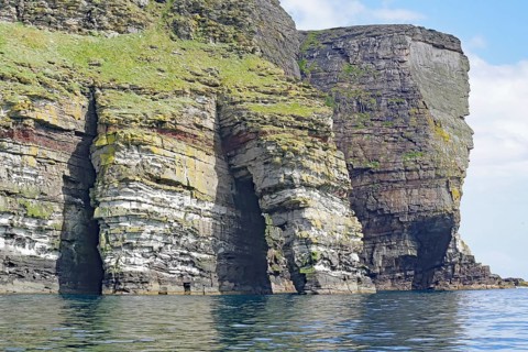 Dramatic cliffs with geological stratification over the sea, Isle of Noss, Shetland Islands,