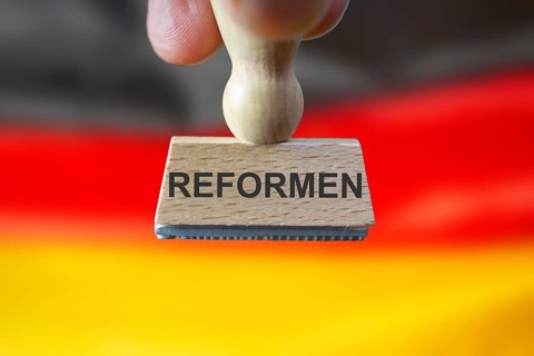 (Photomontage) Stamp with the inscription REFORMEN in front of a German flag