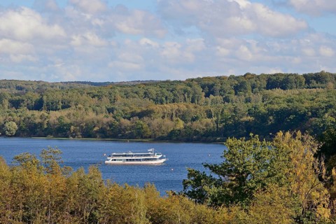 View of the Möhnesee with the passenger ship MS Möhnesee, autumn atmosphere, blue cloudy sky,