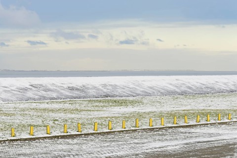North Sea coast on a winter's day, snow-covered dyke and boundary posts, North Sea, Norddeich,