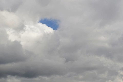 Cloud formation, blue sky shines through a gap in the closed cloud cover, North Rhine-Westphalia,