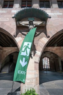 Exit sign in front of a Christ cross in the courtyard of the Heilig Geist Spital, Nuremberg, Middle