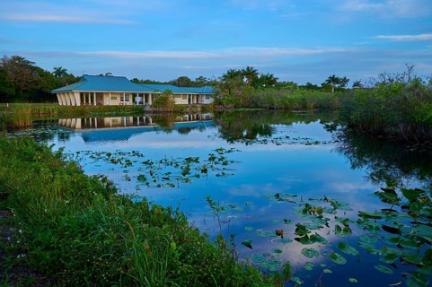 A house by a pond with water reflections and peaceful surroundings, Royal Palm Visitor Centre,