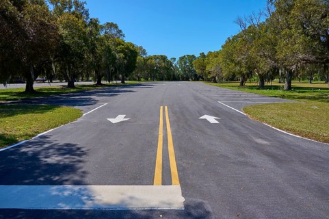 An empty car park with lane markings surrounded by trees, Flamingo, Everglades National Park,