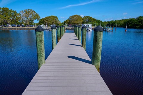 Wooden walkway leads over calm water to a boat dock, Flamingo, Marina, Everglades National Park,