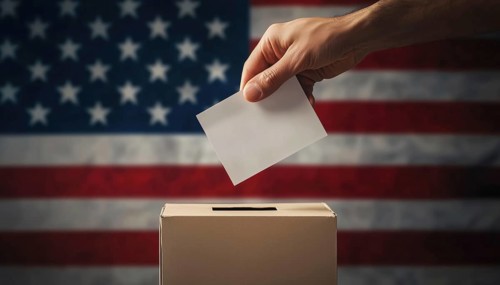 Hand Holding Ballot And Ballot Box Placed On American Flag, Symbolizing Voting In The United States