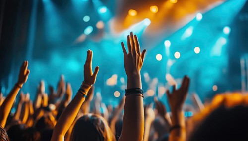 Rock Concert Fans Clap Hands And Wave In Club With Blue Bright Stage Lights, Enjoying Dj Show At