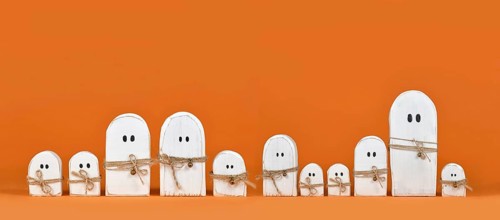 Banner with cute wooden white Halloween ghost ornaments in a row on orange background