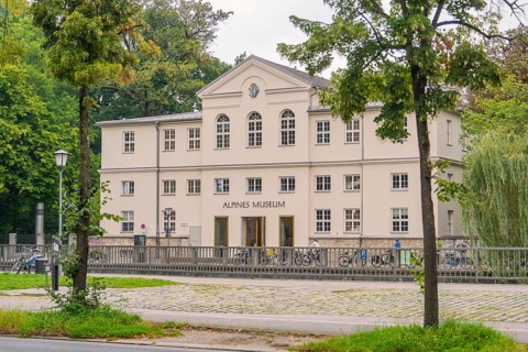 Front view of the Alpine Museum, framed by trees. A classic building in an urban environment,