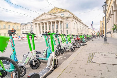 E-scooters and bicycles in front of a majestic building in the city of Munich, Munich, Germany