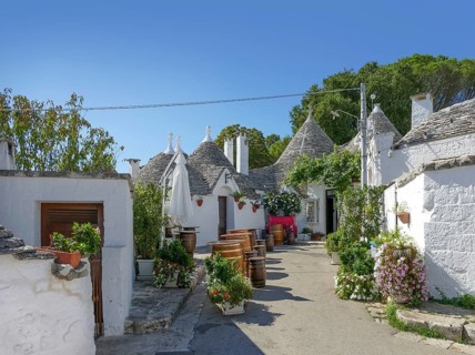 Sunny impression of trulli houses at a town named Alberobello in Apulia, Italy