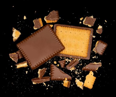 Butter biscuit cakes with chocolate and lots of broken pieces around in black back