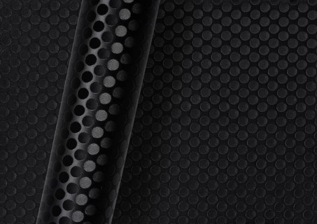 Rolled dark round dotted surface over same full frame textured background