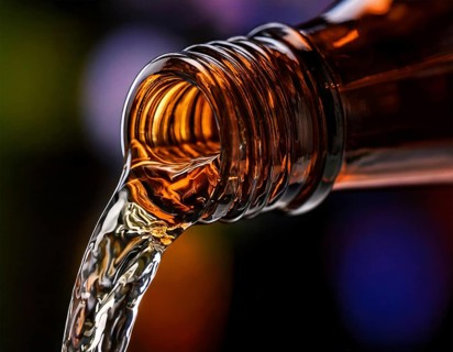 AI-generated close-up image showing a bottle as a clear drink is poured from it, AI generated