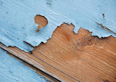 Detail of blue flaking paint on wooden surface