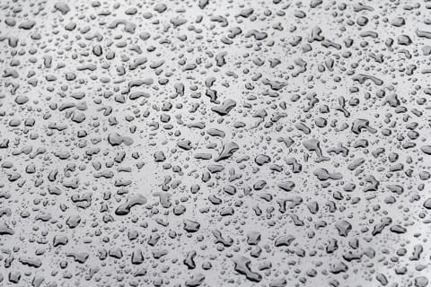 Abstract natural background showing a closeup of water beads on glossy repellent ground