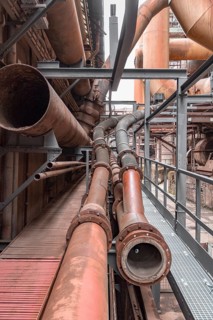 Weathered rusty industrial scenery with old corroded steel girders and metal tubes